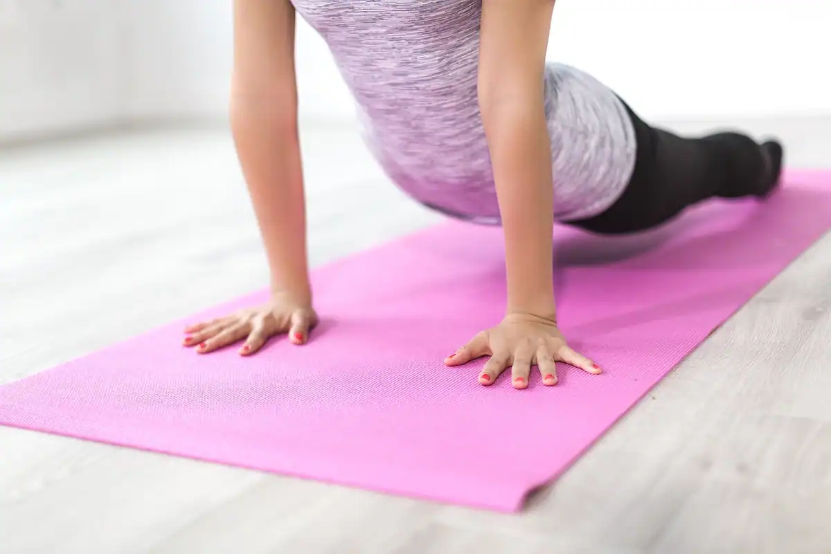 Saltea de yoga și sticlă cu apă într-o încăpere, pentru o zi de pauză activă între alergări
