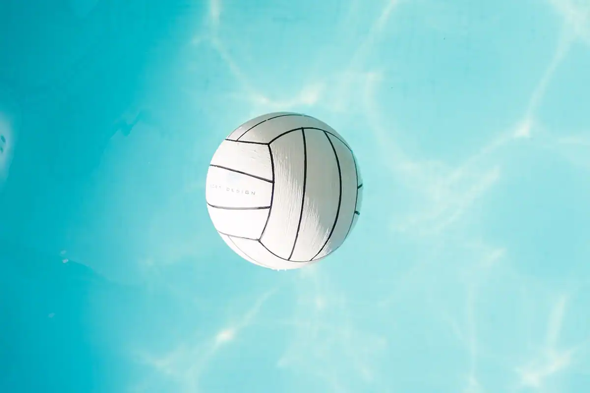 Minge de volei pe podeaua unei săli de sport, aproape de linia terenului