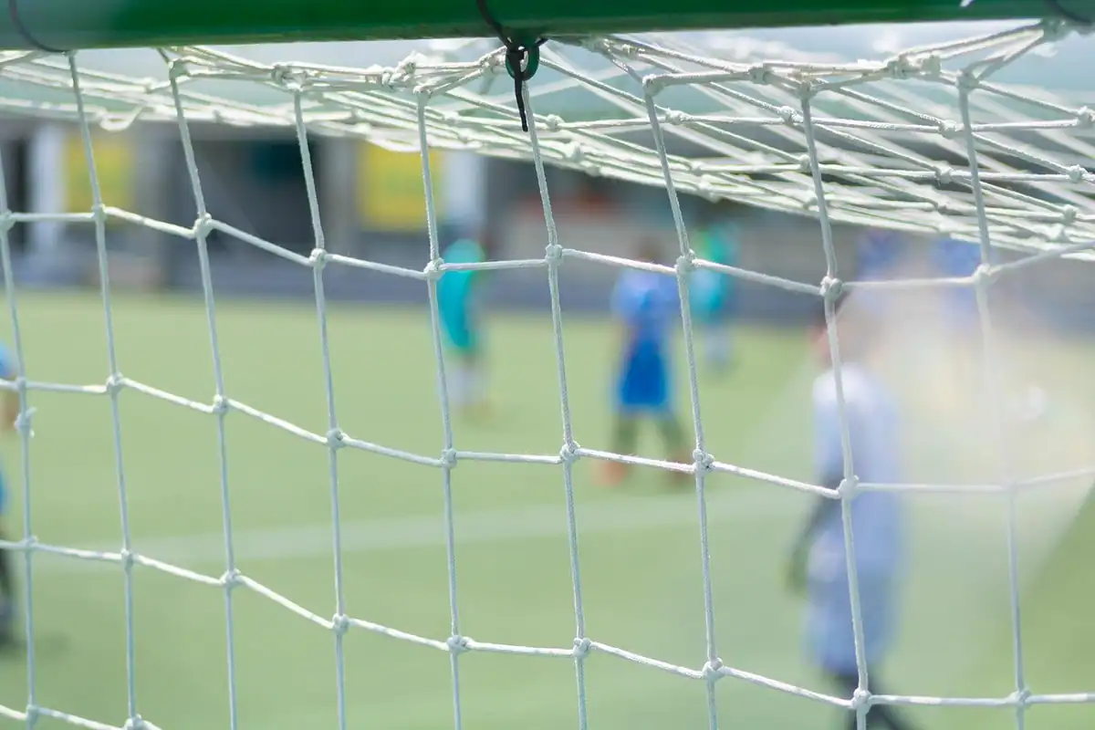Poartă de fotbal cu plasă și bară transversală, văzută de aproape, ținta loviturii de pedeapsă