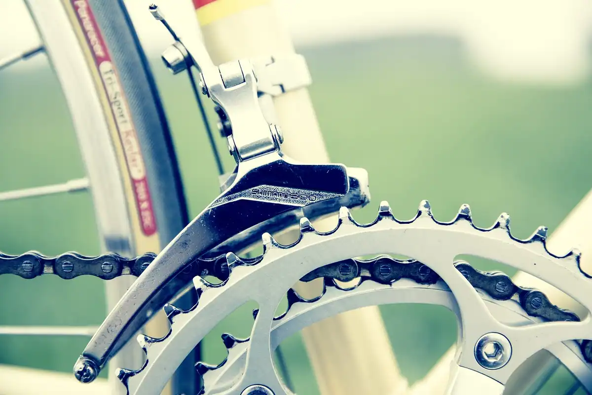 Pedale de bicicletă văzute de aproape, lângă lanț și pinionul pedalierului