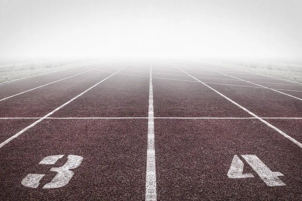 Pistă de atletism învăluită în ceață, cu numerele culoarelor trei și patru