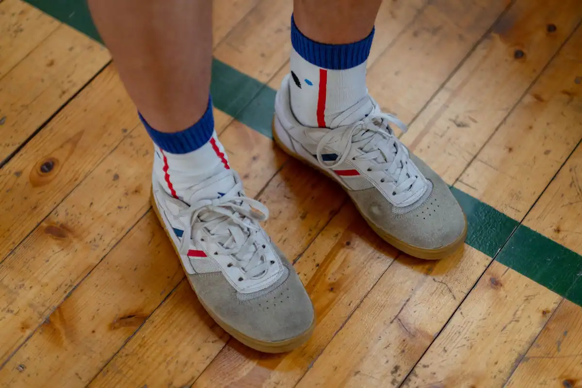 Adidași și șosete văzute de aproape, pe podeaua unei săli de sport