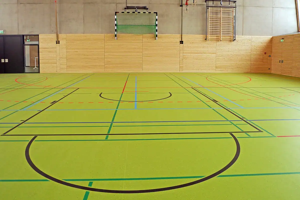 Sală de sport cu marcaje pentru mai multe jocuri și poartă de handbal