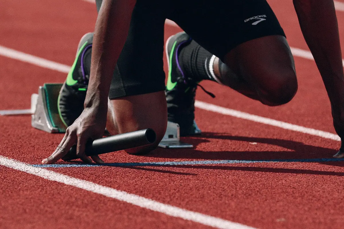Sprinter în blocstarturi pe pista de atletism, gata de plecare